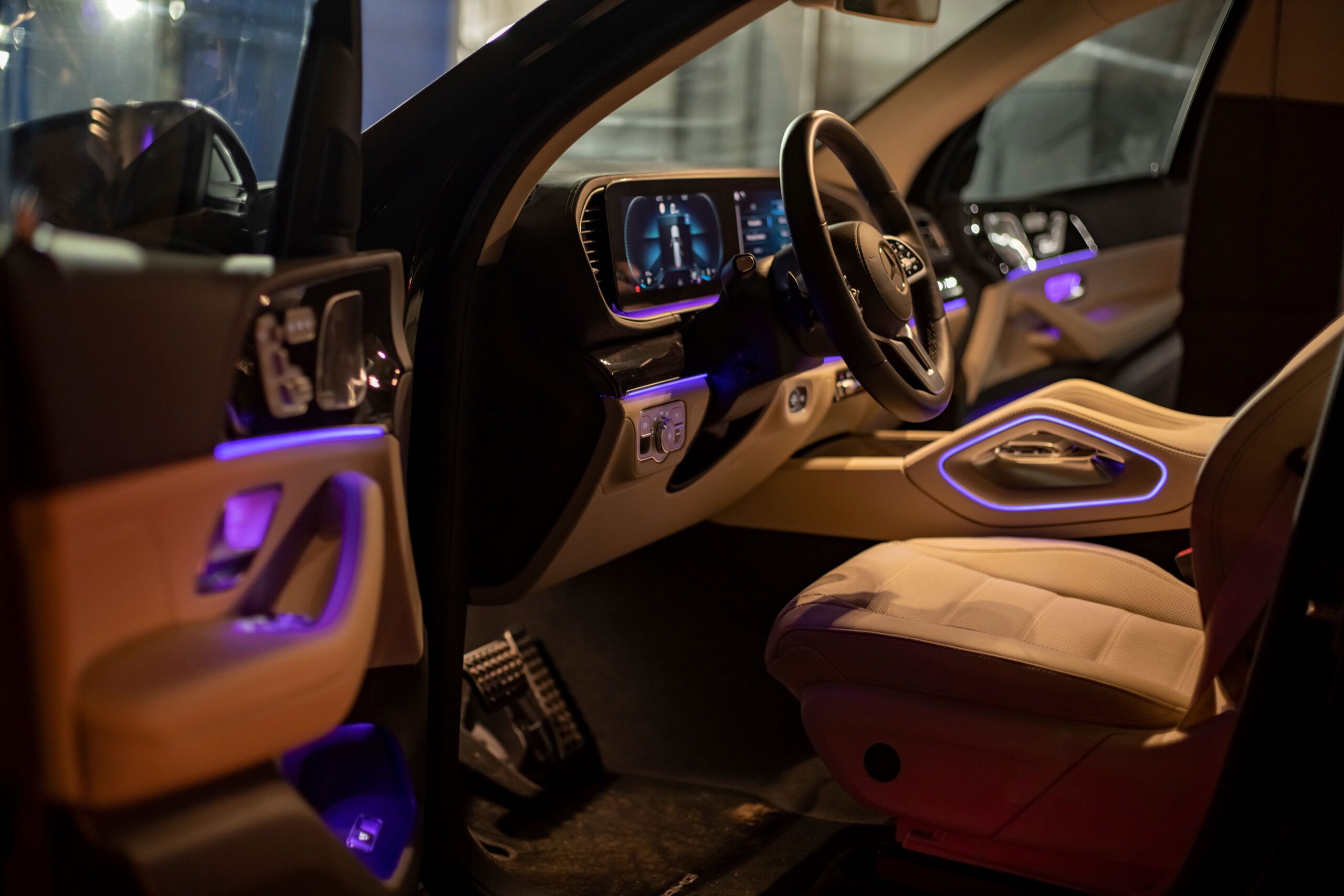 Leerer Innenraum aus hellem Leder des Premium-SUV Mercedes GLS-Klasse bei Nachtaufnahmen. mit LED-Ambiente-Hintergrundbeleuchtung